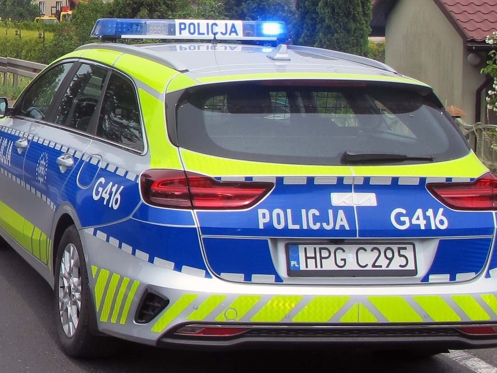 Samochód policyjny na sygnale być może koło Oświęcimiu w Osieku
